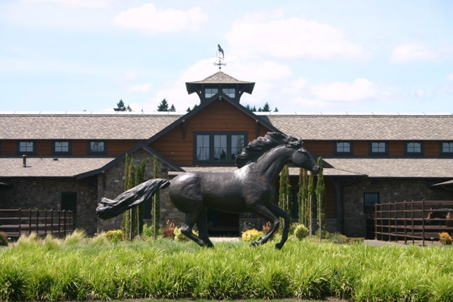 Large running horse statue in front of the barn